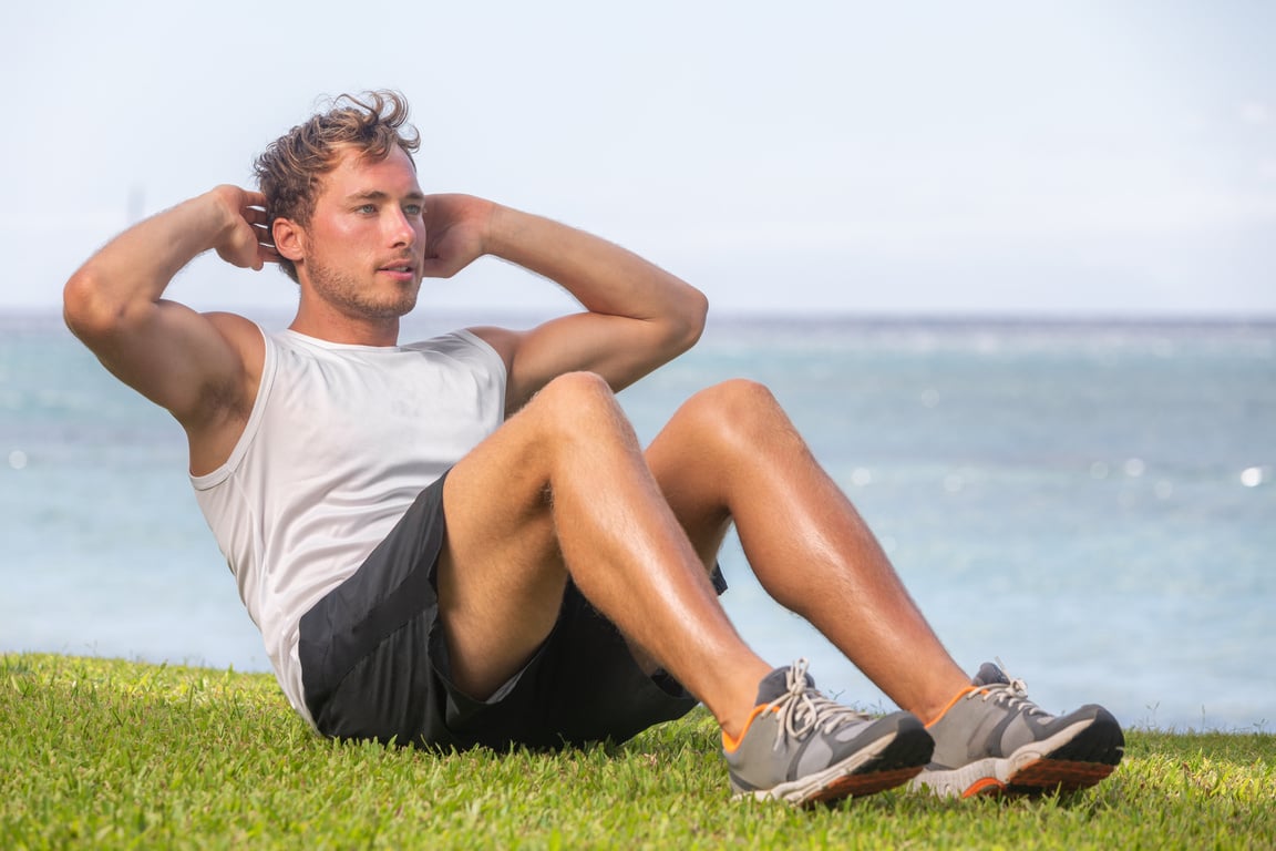 Fit Man Athlete Training outside on Grass Doing Situps for Abs Workout Fat Belly Weight Loss. Healthy Active Lifestyle